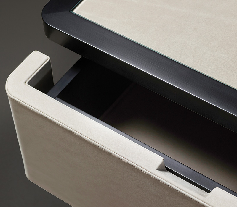 Drawer detail of Au Bout de la Nuit, a wooden bedside table with drawers, bronze base and top covered in leather with glass, from Promemoria's Amaranthine Tales collection | Promemoria