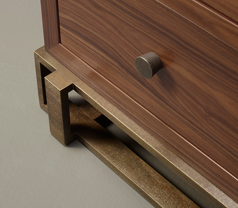 Bronze base and knobs detail of Margot, a wooden chest of drawers with metal details from Promemoria's catalogue | Promemoria