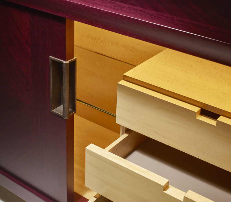 Drawers' detail of Oolong, a low wooden cabinet with sliding doors with leather shelves and drawers fronts and bronze handles from Promemoria's catalogue | Promemoria