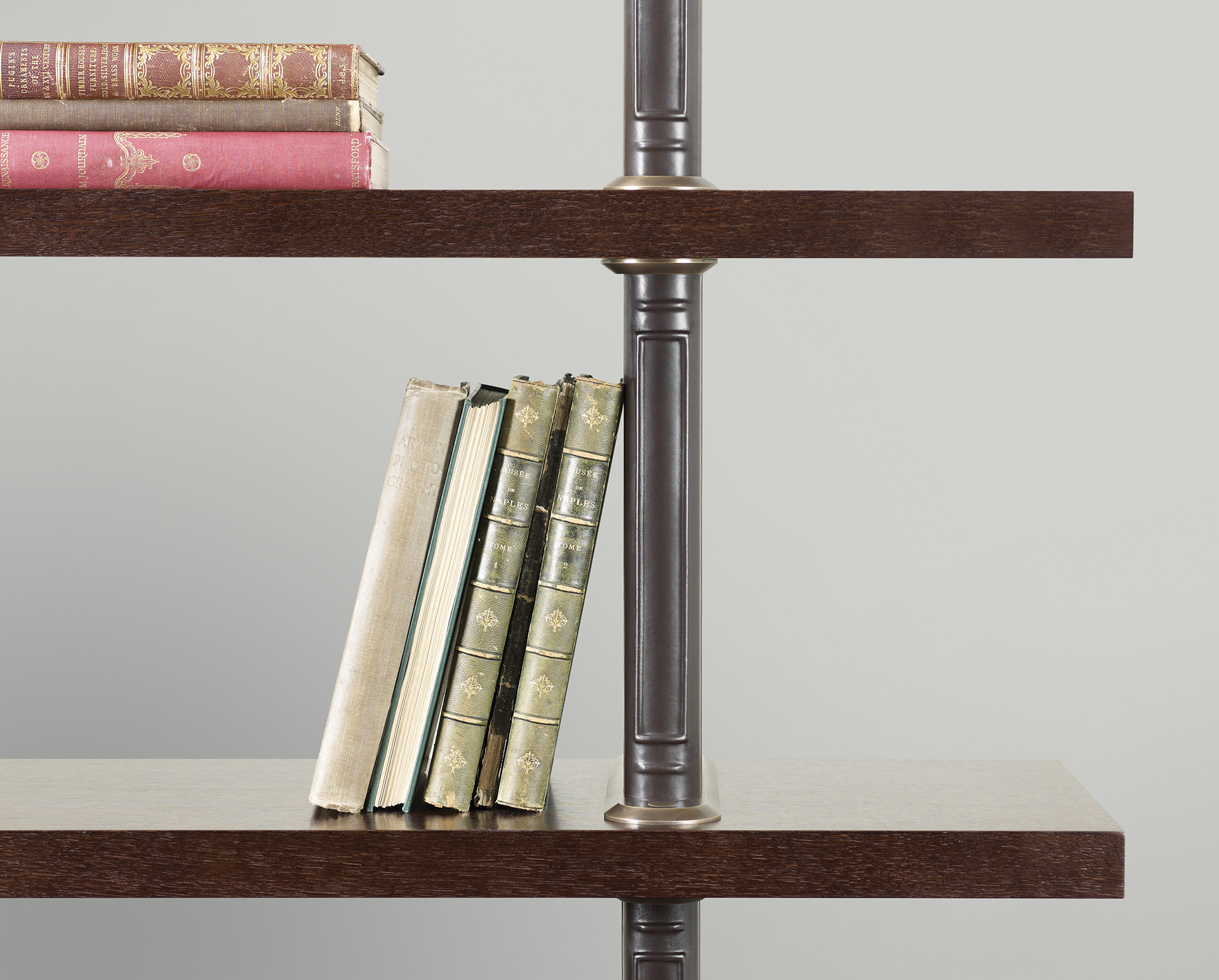 Detail of Peggy, a modular wooden bookcase with leather covered supports and bronze details, from Promemoria's catalogue | Promemoria