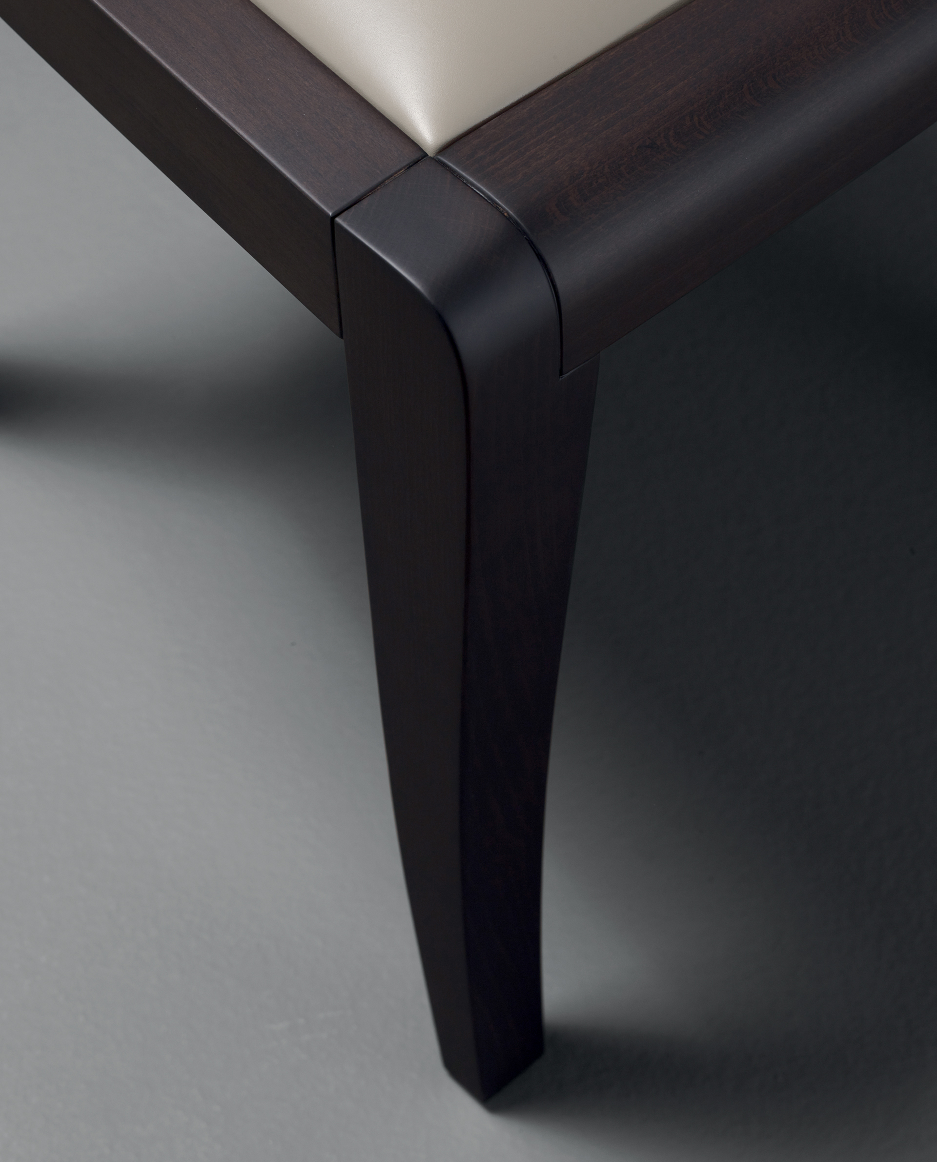 Armrest detail of Eloise, a wooden dining chair with leather seat, available with or without armrests from Promemoria's catalogue | Promemoria