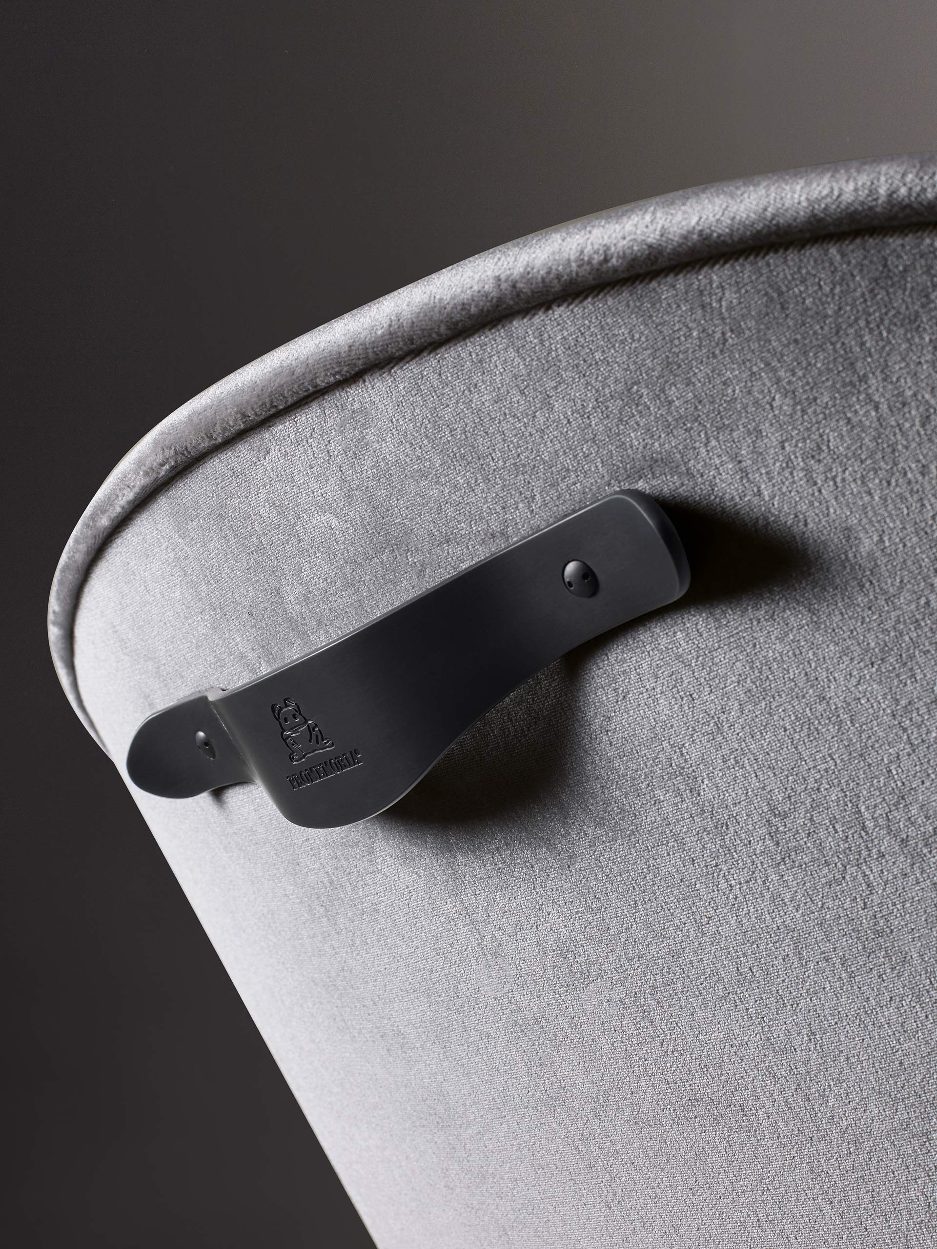 Bronze handle detail of Vittoria, a wooden chair covered in fabric or leather, from Promemoria's catalogue | Promemoria