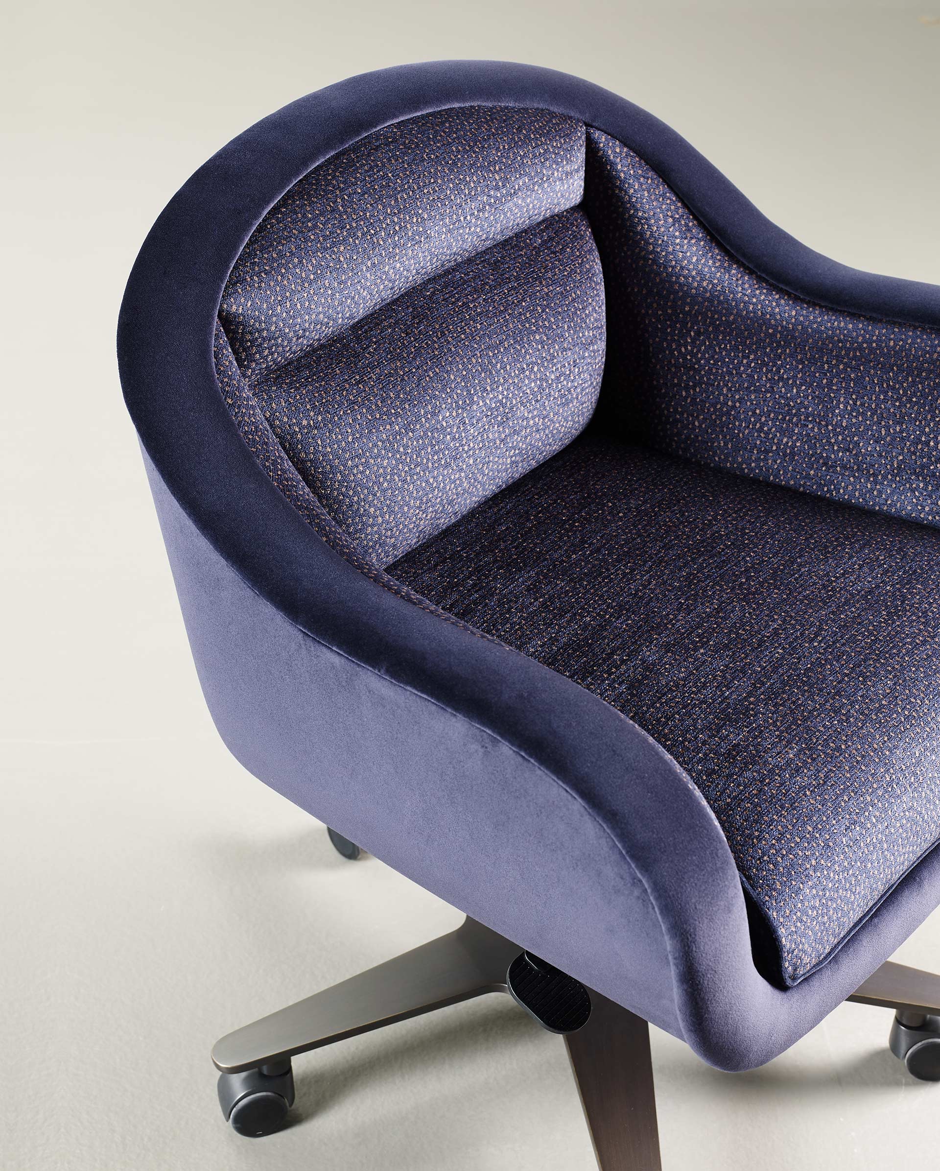 Vittoria is an office chair with a metal or bronze base, covered in fabric or leather with a bronze handle on the back, from Promemoria's catalogue | Promemoria