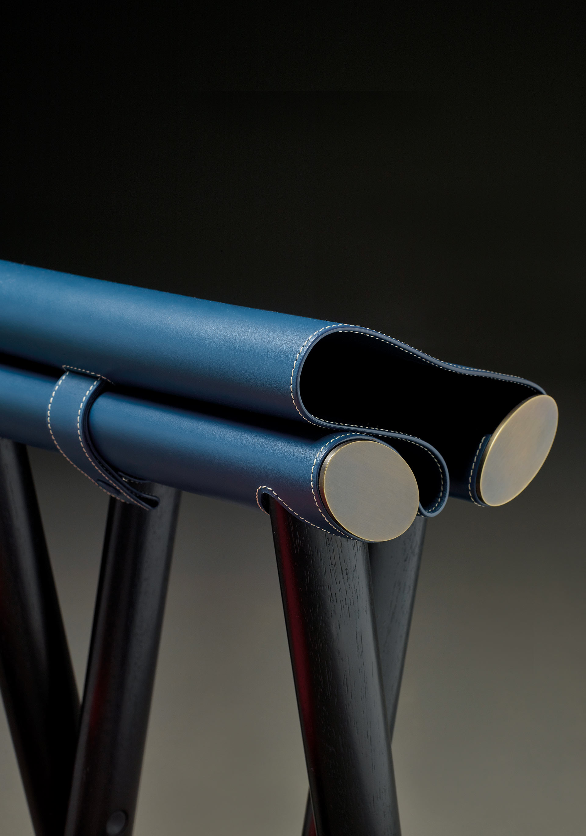 Detail of Petit Nyx and Grand Nyx, two folding wooden stools with bronze details and leather seat, from Promemoria's Night Tales collection | Promemoria