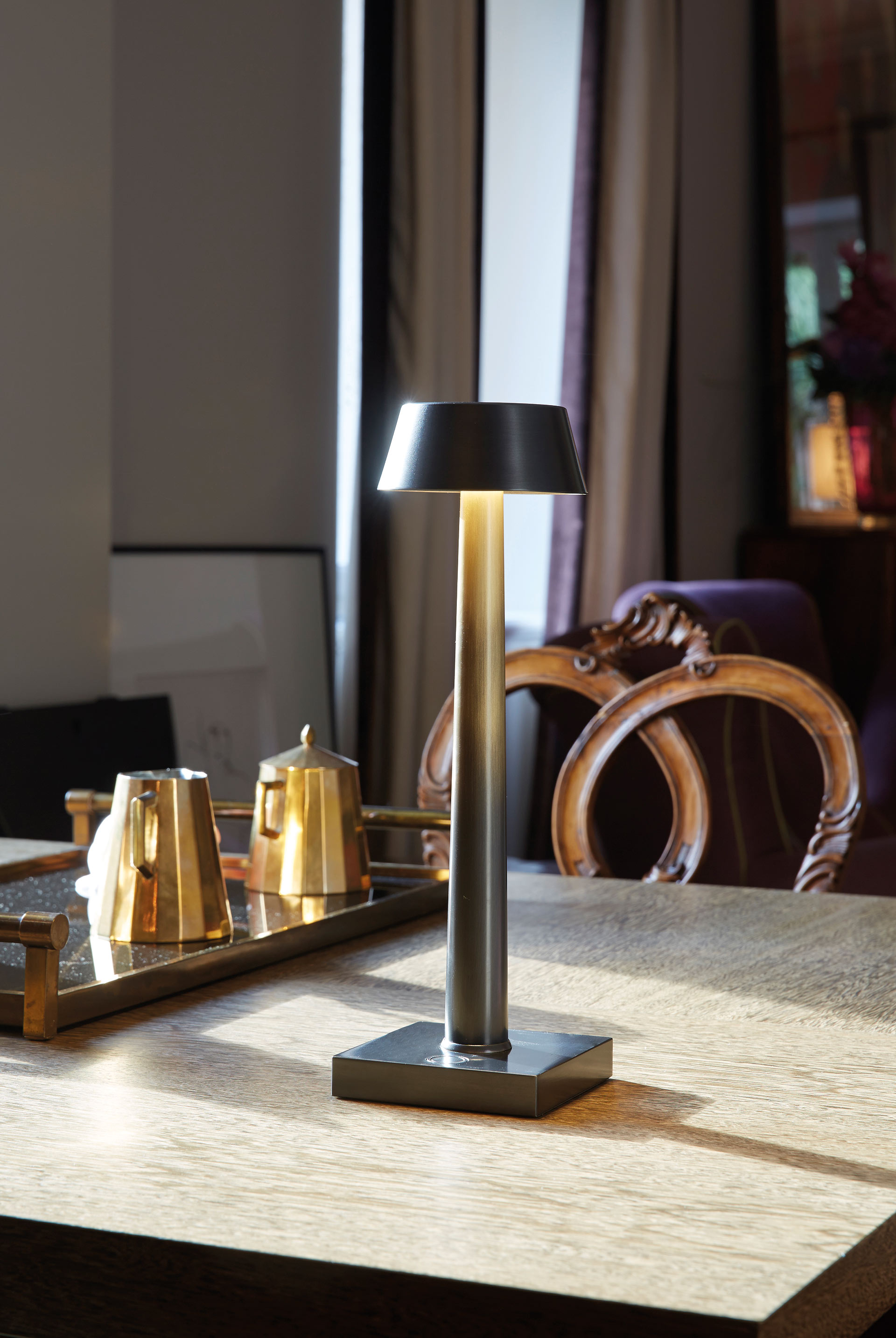 Fiammetta is a portable table LED lamp with bronze structure and touch switch, from Promemoria's catalogue | Promemoria
